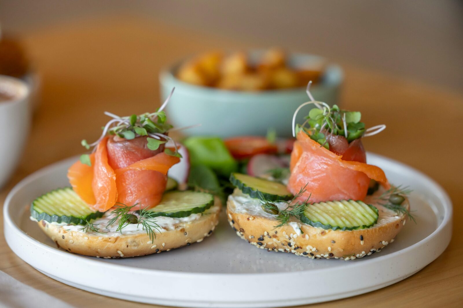 Delicious bagels topped with smoked salmon, cucumber, and cream cheese for a gourmet breakfast.